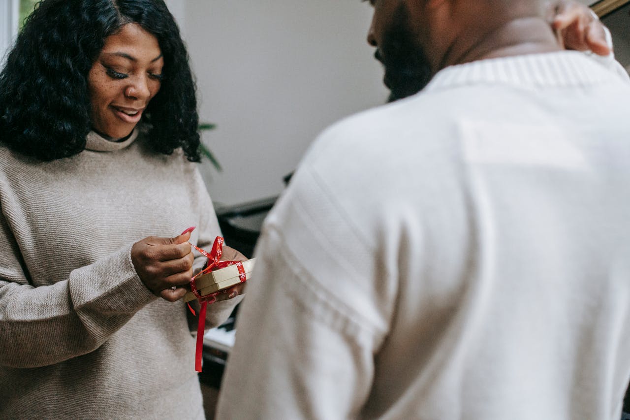 Black couple in sweaters congratulating each other on Christmas